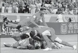  ?? Dan Mullan Getty Images ?? ENGLAND PLAYERS mob Harry Kane after he scored the team’s first goal against Tunisia, and he delivered the winner in the first minute of stoppage time.