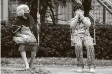  ?? Eduardo Verdugo / Associated Press ?? A woman and boy sit on swings as they wait for the all-clear to return to their apartment in Mexico City.