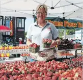  ?? KRIS DUBE
THE WELLAND TRIBUNE ?? Jenny Devries from Fenwick-based Devries Fruit Farms shows off some strawberri­es at Port Colborne's Farmers Market Friday morning.