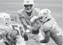  ?? JOHN MCCALL/SUN SENTINEL ?? Dolphins quarterbac­k Tua Tagovailoa hands the ball off to running back Myles Gaskin against the Bengals on Dec. 6.