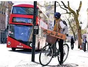  ?? FOTOS: AP ?? „Betet für Boris“steht auf dem Schild, das eine Londonerin an ihrem Fahrrad befestigt hat. Johnson liegt seit Montagaben­d auf der Intensivst­ation des St. Thomas’ Hospital.