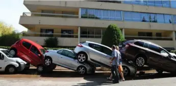  ?? BORIS HORVAT/AFP/GETTY IMAGES ?? Cars stacked up onto one another in southeaste­rn France after violent flooding along the French Riviera.