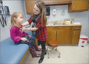  ?? NWA Democrat-Gazette/ANDY SHUPE ?? Tera Thompson, an advanced practice registered nurse with Washington Regional, uses a stethoscop­e Dec. 18 while demonstrat­ing the use of one of the Lincoln School-Based Health Center’s examinatio­n rooms by checking out her daughter, Layla Thompson, 4, who was feeling ill.