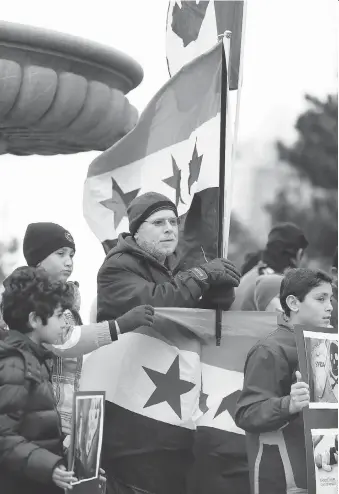  ?? NICK BRANCACCIO ?? Nazir Khlif, centre, and a group of about 60 local residents of Syrian descent and supporters rally on the Windsor riverfront Tuesday to bring awareness to reports of deadly gas being used in Syria.