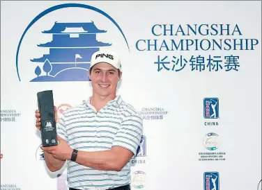  ?? PROVIDED TO CHINA DAILY ?? Charlie Saxon of the US poses with the trophy after winning the Changsha Championsh­ip at Hunan Dragon Lake Internatio­nal Golf Club on Monday. Tournament play was suspended twice on Sunday due to severe thundersto­rms.