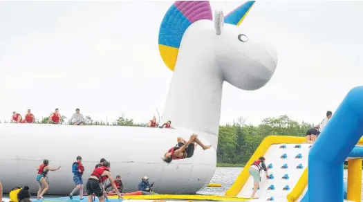  ?? RYAN TAPLIN • THE CHRONICLE HERALD ?? A visitor to Splashifax does a flip on a trampoline during a friends and family event at the new inflatable water park in Hammonds Plains on Thursday. Splashifax opens to the public Friday.