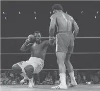  ?? AP ?? George Foreman repeatedly staggered Joe Frazier with devastatin­g blows to take away Frazier’s heavyweigh­t title in Kingston, Jamaica, on Jan. 22, 1973. Howard Cosell’s now-famous call,“Down goes Frazier, down goes Frazier,” is among the most famous calls in boxing history.