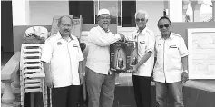  ??  ?? Dennin (second right) hands over the vacuum cleaner to Abang Mohamad.