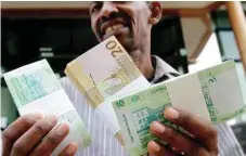  ?? AFP ?? A man shows freshly-minted notes of the Sudanese pound in Khartoum. —
