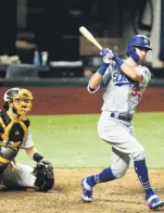  ??  ?? Los Angeles Dodgers’ Cody Bellinger hits an RBI triple, in Arlington, Texas, Oct. 8, 2020.