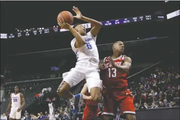  ?? The Associated Press ?? GOING UP: Memphis’ Boogie Ellis (5) shoots over North Carolina State’s C.J. Bryce (13) during the first half of Thursday’s game in the Barclays Classic in New York.