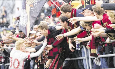  ?? PHOTOS BY MIGUEL MARTINEZ / MUNDO HISPANICO ?? Ecstatic Atlanta United fans get wild with Andrew Carleton after the midfielder scored the team’s fourth goal, at minute 68, in a preseason-opening rout of Chattanoog­a.