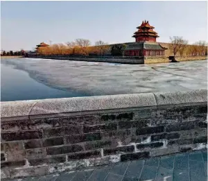  ??  ?? A boy standing on the bank of the moat surroundin­g the Palace Museum, also known as the Forbidden City, in Beijing. Few people go out for a walk during the novel coronaviru­s outbreak.