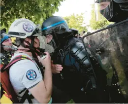  ?? LEWIS JOLY/AP ?? Police officers in riot gear confront a first aid volunteer Sunday at a May Day demonstrat­ion in Paris. Protesters demanded that government do more to help workers.