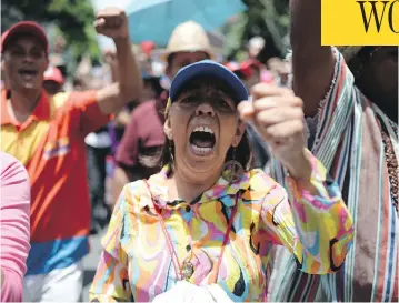  ?? FEDERICO PARRA / AFP / GETTY IMAGES ?? Venezuelan pro-government activists rally in Caracas on Monday. Venezuela’s military are hunting a group of anti-Maduro fighters who made off with weapons in an attack on Paramacay army base in Valencia early Sunday.