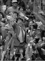  ?? LEONARD IGNELZI — THE ASSOCIATED PRESS ?? In this April 4, 1983file photo, North Carolina State coach Jim Valvano holds the net aloft after his team defeated