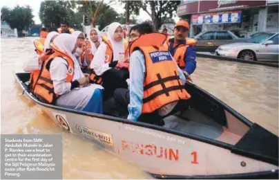  ??  ?? Students from SMK Abdullah Munshi in Jalan P. Ramlee use a boat to get to their examinatio­n centre for the first day of the Sijil Pelajaran Malaysia exam after flash floods hit Penang.