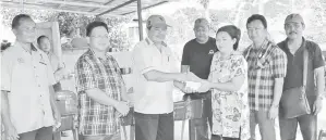 ??  ?? EWON menyampaik­an sumbangan RM3,000 kepada Ketua Wanita Kg Kinaratuan Rusinah Sami.
