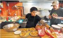  ??  ?? Kitchen staff serve up burgers and fries. “The first year was hard,” said Tommy Petropoulo­s, above right, who opened Harry’s Charbroile­d in 1968. “But we worked hard and things worked out for us.”