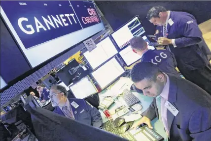  ?? Richard Drew / Associated Press ?? A 2014 photo shows the post that handles Gannett on the New York Stock Exchange floor. Gannett on Monday rejected a $1.36 billion buyout offer from a media group with a history of taking over struggling newspapers and slashing jobs. Senate Minority Leader Charles E. Schumer is concerned about the potential deal.