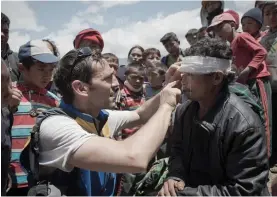  ?? — AFP ?? A villager is checked for an eye injury by a French doctor in the village of Barpak in north central Nepal on Monday.