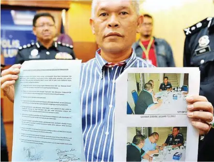  ??  ?? Police evidence: DCP Mohamad showing the document and a picture of Shamsul Iskandar signing a document in Kuala Lumpur yesterday. — Bernama
