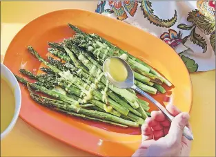 ?? MIA VIA AP ?? This November 2016 photo shows roasted asparagus with lemon dressing in New York. This lemon sauce is a simple way to dress up roasted asparagus, the pinup vegetable of spring. It’s also good for any simply cooked asparagus, such as grilled, steamed or...
