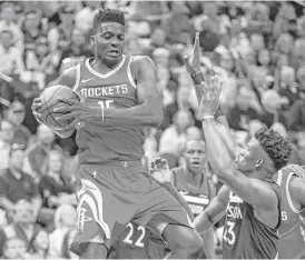  ?? Michael Ciaglo photos / Houston Chronicle ?? Rockets center Clint Capela, left, snares a rebound away from Timberwolv­es guard Jimmy Butler, right, during the first half Monday night.