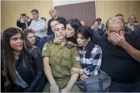  ??  ?? EMOTIONS RUN HIGH as family members surround Sgt. Elor Azaria and wait to hear the court’s verdict as his lengthy trial came to an end yesterday.