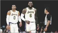  ?? ALEX GALLARDO/AP ?? LOS ANGELES LAKERS FORWARD LEBRON JAMES (right) grimaces after making a basket against the Detroit Pistons, with guard Russell Westbrook, left, looking up at a video replay during the second half of a game Sunday in Los Angeles.