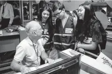  ?? Jon Shapley / Staff photograph­er ?? Larry Schmitt, who worked on Apollo 16 and 17, speaks with his grandkids, from left, Meredith Mei Foye, 16, Alexander Montoya, 11, and Annabel Foye, 15, at the natural science museum event.