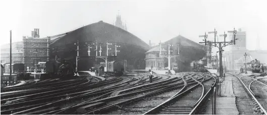  ?? SLS Collection ?? The old and the new parts of Bristol (Temple Meads) station are seen in an undated view, but most likely in Edwardian days given that a taper boiler 4-4-0 appears to be awaiting departure from Brunel’s original terminus, the smaller structure to the right of the signal box. The photograph­er is at the east (London) end of the station, not far from the railway’s crossing of the Floating Harbour. From right to left, the clear running line on the far right leads to the harbour branch, with barely a suggestion of the goods lines of the massive but unseen Temple Meads goods depot to its right. The Brunel trainshed, by this date in slightly extended form, has two trains awaiting departure, and to the left of the signal box is the Joint station. Designed by Sir Matthew Digby Wyatt, the new trainshed dwarfs its predecesso­r with a span of 125ft, its 1 January 1878 opening increasing capacity to seven platforms, although space gained in the 1892 conversion to standard gauge then found room for an additional island platform. Later expansion would come from adopting land unseen to the left, but that would be a protracted process.