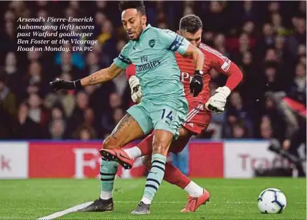  ?? EPA PIC ?? Arsenal’s Pierre-Emerick Aubameyang (left) scores past Watford goalkeeper Ben Foster at the Vicarage Road on Monday.