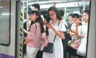  ?? ZHANG YANG / FOR CHINA DIALY ?? Passengers read e-books on mobile devices on a subway train in Guangzhou, Guangdong province.