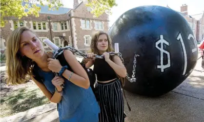  ??  ?? Students activists at Washington University in St Louis pull a mock ball and chain representi­ng student debt. Photograph: Paul J. Richards/ AFP/Getty Images