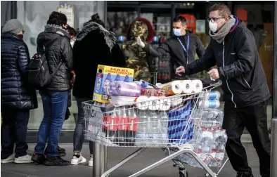  ?? FOTO: CLAUDIO FURLAN/TT-AP ?? Människor med munskydd köar för att köpa på sig förnödenhe­ter inför vad som kan bli flera veckors isolering, på den italienska orten Casalpuste­rlengo.