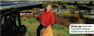  ??  ?? Clear-up Volunteer Tracy Rich removes rubbish from Mote Hill