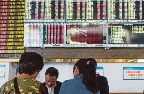  ?? [ FOTO AFP ] ?? Saham China turut merosot dengan penanda aras Shanghai Composite menyusut 1.5 peratus.