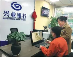  ?? CHEN JIA / CHINA DAILY ?? A worker (left) at Geely Auto Group’s Chunxiao Manufactur­ing Plant in Ningbo, Zhejiang province, applies for a consumer loan using online services of Industrial Bank.