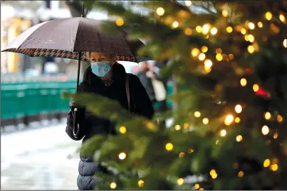  ?? The Associated Press ?? CLOSED SHOP: A pedestrian passes Christmas decoration­s of a closed shop Wednesday in Oxford Street in London. Britain’s Prime Minister Boris Johnson imposed a new, higher level of coronaviru­s restrictio­ns to curb sharply spreading infections in the capital and other areas.