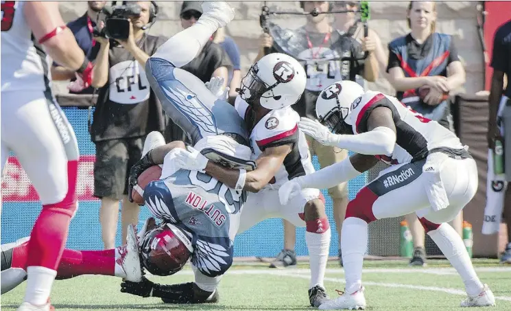  ?? GRAHAM HUGHES/THE CANADIAN PRESS ?? Montreal Alouettes running back Tyrell Sutton is halted by the Ottawa Redblacks defence during the first half in Montreal on Sunday.