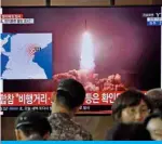  ?? — AFP ?? SEOUL: People watch a television news screen showing file footage of North Korea’s missile launch, at a railway station in Seoul yesterday.