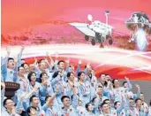  ??  ?? Workers at the Beijing Aerospace Control Center celebrate Saturday after the Mars craft landed.