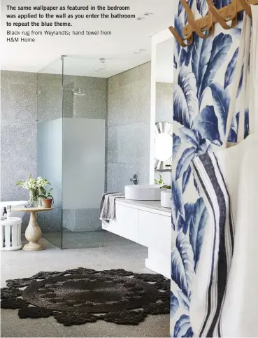  ??  ?? The same wallpaper as featured in the bedroom was applied to the wall as you enter the bathroom to repeat the blue theme.
Black rug from Weylandts; hand towel from
H&M Home