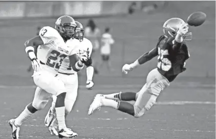  ?? DALE L. ANDERSON ?? Anthony Miller (25) gives maximum effort trying to make the catch early against White Station defenders Donald Gray (23) and Anthony Upchurch on Sept. 7, 2012.