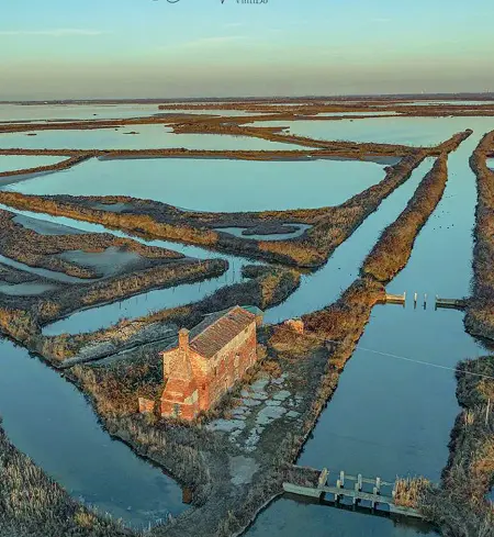  ?? ?? Album
La laguna di Venezia a Lio Piccolo. (foto Claudio Vianello) e la casa nelle barene. A sinistra la targa che su Palazzo Boldù ricorda la costruzion­e del campanile e del pozzo artesiano e un attracco