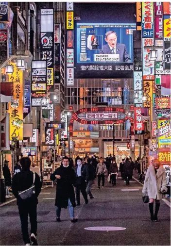  ?? FOTO: P. FONG/AFP ?? Ein Bildschirm in Tokio zeigt den japanische­n Premiermin­ister Yoshihide Suga während einer Verkündung.