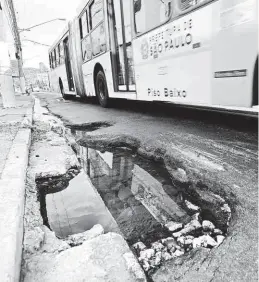  ?? Rivaldo Gomes/Folhapress ?? Ônibus passa ao lado de buraco na altura do número 3.300 da avenida Celso Garcia, na zona leste; 96 pedidos de conserto por km