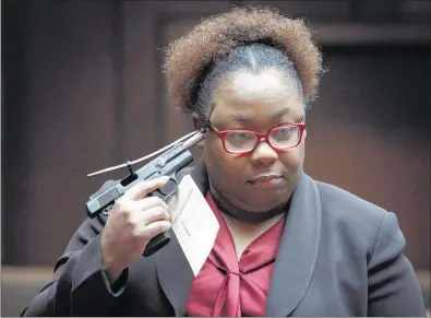  ?? PHOTOS BY MIKE BROWN/THE COMMERCIAL APPEAL ?? Assistant District At torney Glenda Adams holds a handgun during the closing arguments in the case of a 2014 shooting involving Misael Chica-Arguenta. He was acquitted of five counts of attempted first-degree murder and found guilty of three counts of...