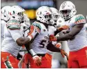  ?? STREETER LECKA /
GETTY IMAGES ?? Miami’s
Mike Smith (center) is congratula­ted after his intercepti­on last season against Appalachia­n State.